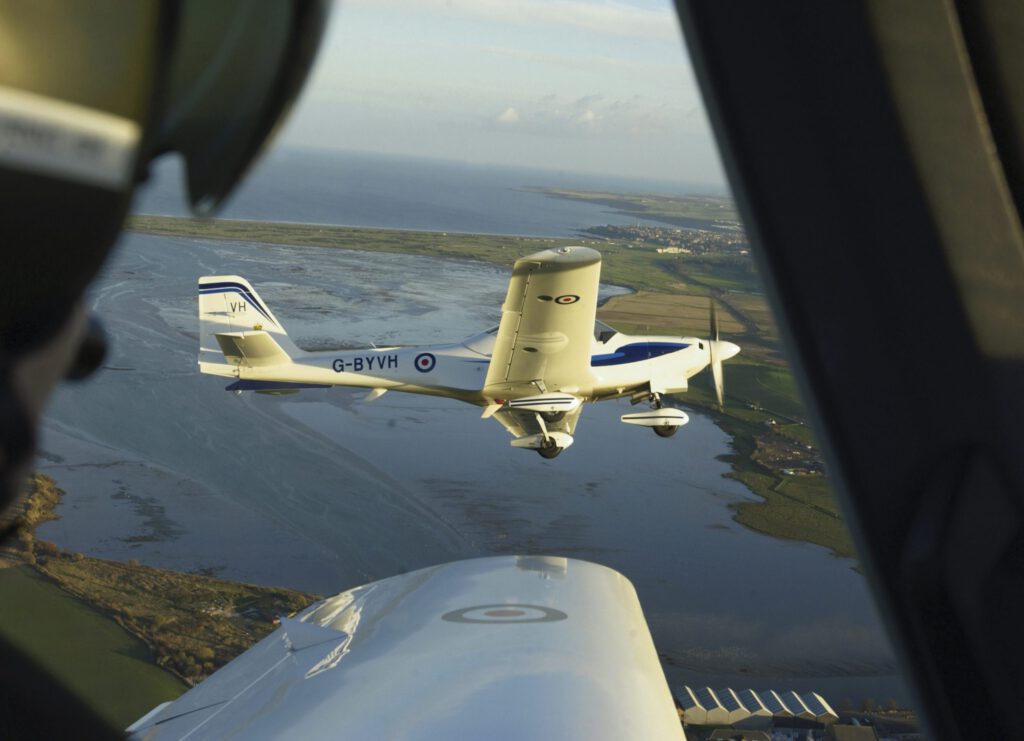 This image was submitted as part of the RAF Photographers Photographic Competition 2005.

Tutor Training Aircraft of the East Scotland University Air Squadron, 4 ship flight, with St Andrews in the distance.